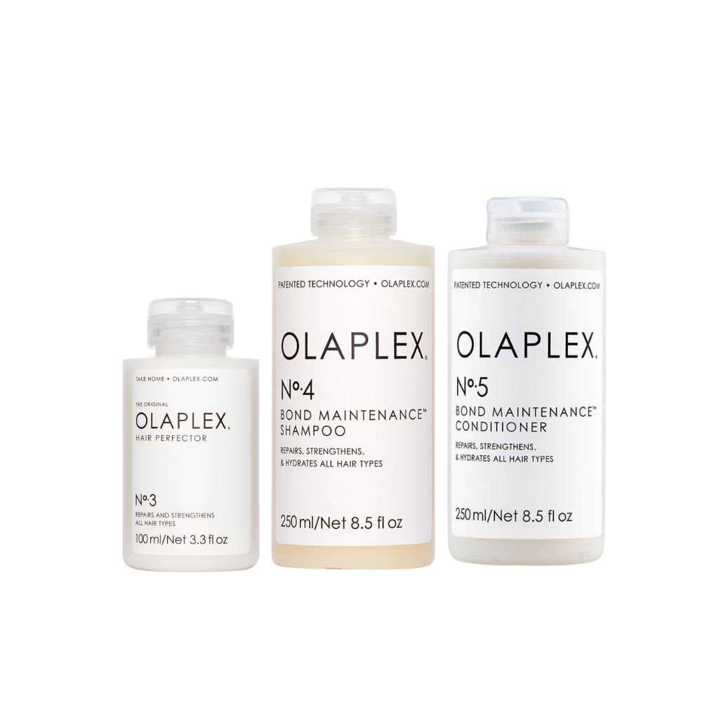 Drei Flaschen Olaplex-Haarpflegeprodukte. Nr. 3, Nr. 4 Shampoo und Nr. 5 Conditioner. Alle Flaschen haben weiße Etiketten.