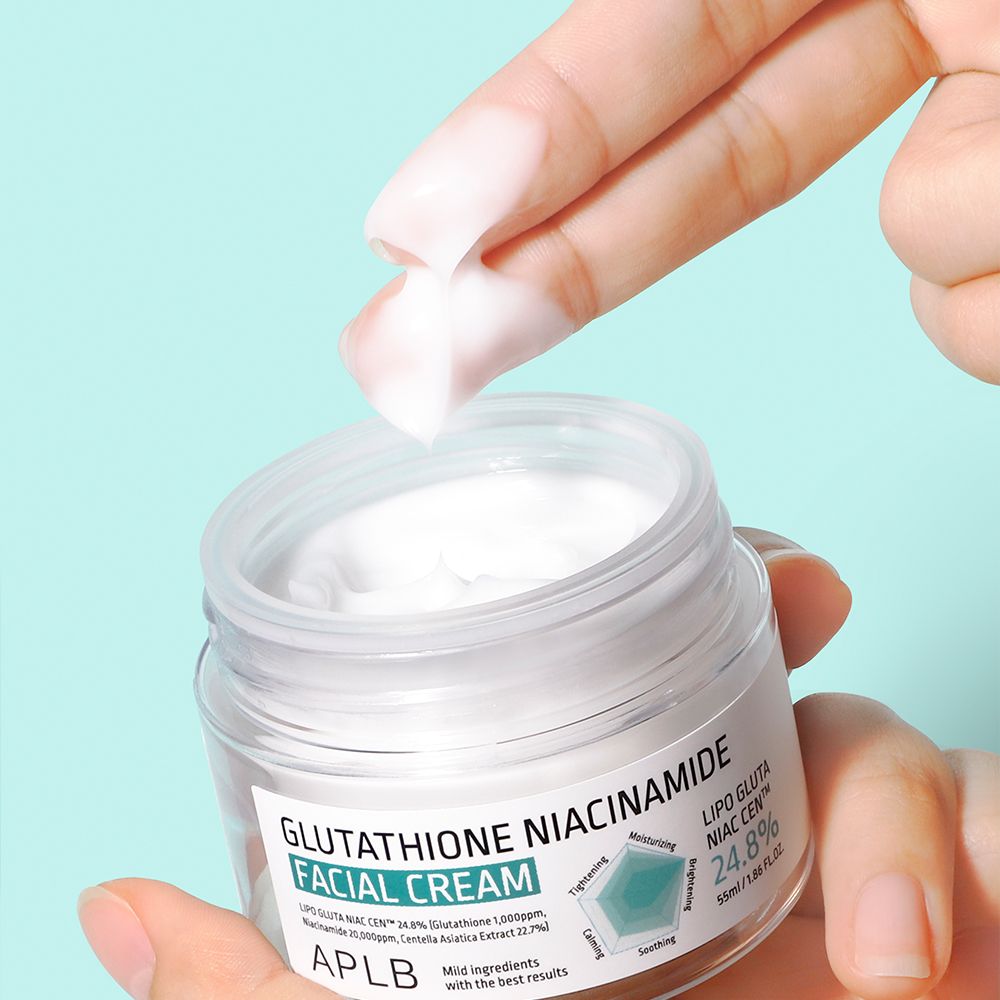 Eine Hand entnimmt APLB Gesichtscreme mit Glutathion und Niacinamid aus einem Glasbehälter.