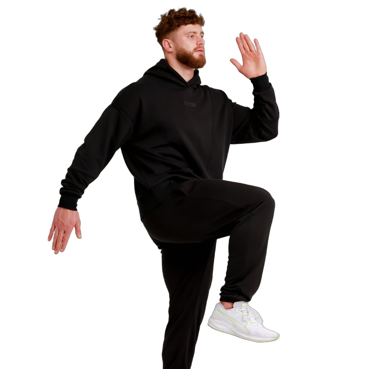 Mann in schwarzer Jogginghose und Kapuzenpullover, Pose zur Demonstration der Hose.