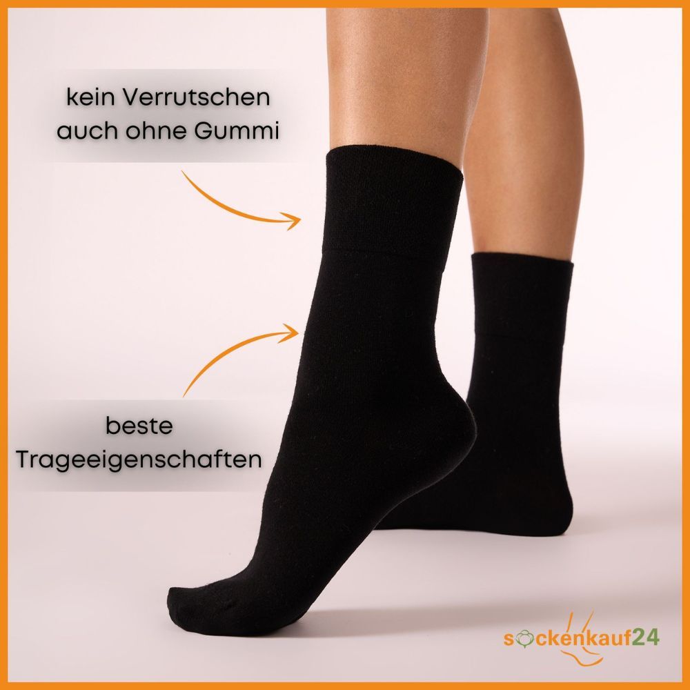 Zwei schwarze Socken am Bein. Text: Kein Verrutschen auch ohne Gummi, beste Trageeigenschaften.