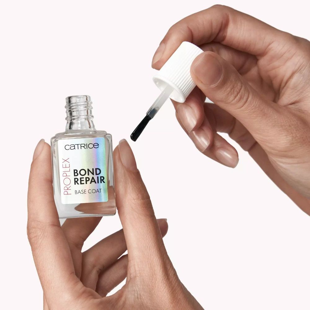 Hände halten eine klare Flasche mit Pinsel. Aufschrift: Catrice, ProPlex, Bond Repair, Base Coat.