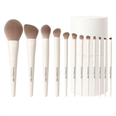 Ein Set von 10 weißen Make-up-Pinseln mit beigen Borsten und einem runden weißen Behälter.