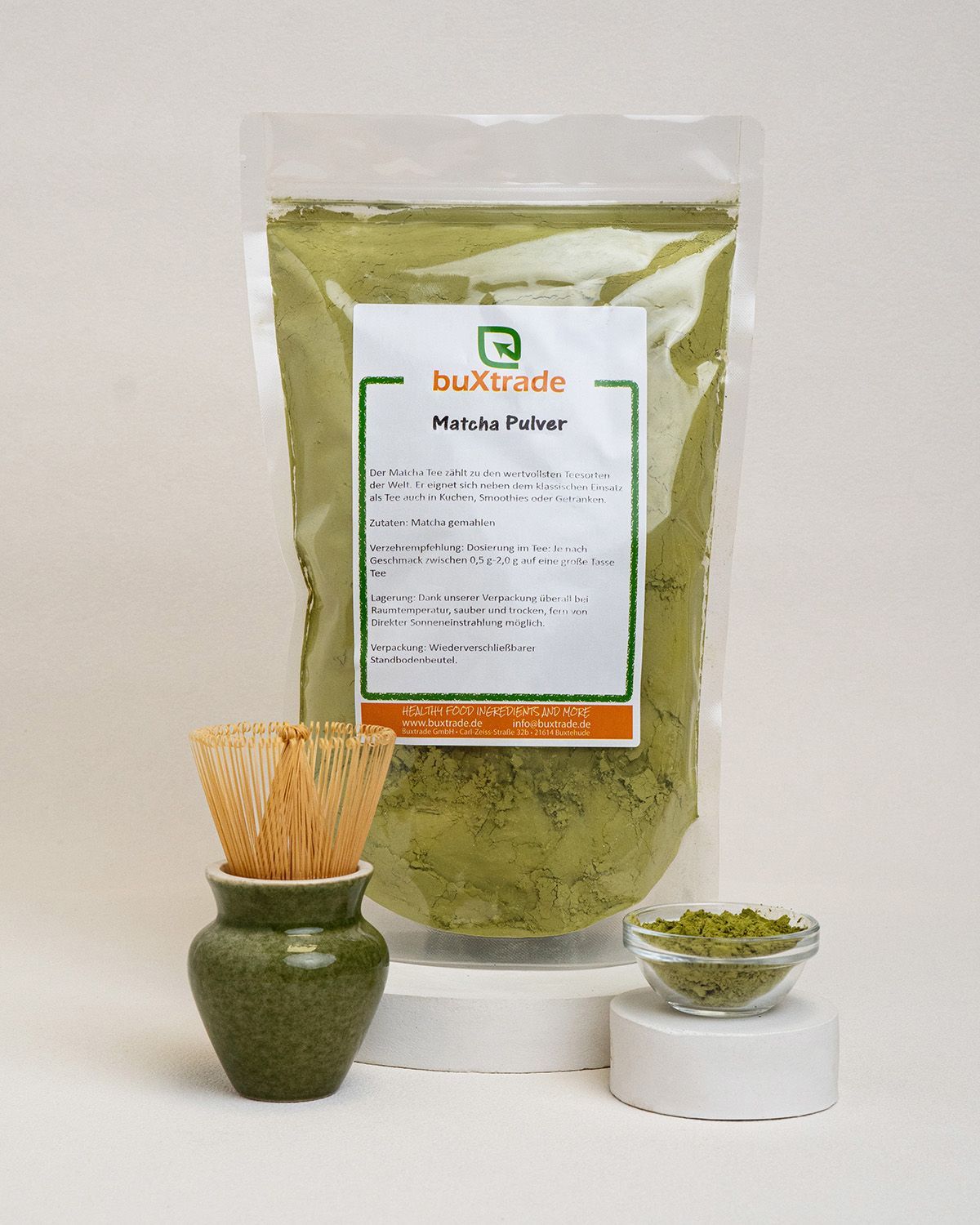 Verpackung mit Matcha-Pulver, Bambusbesen, Keramikhalterung und Schale mit Pulver.