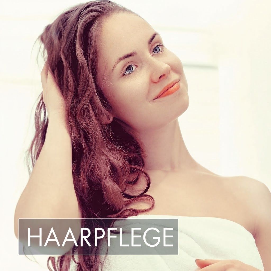 Frau mit langen Haaren, die sich durch die Haare fährt.