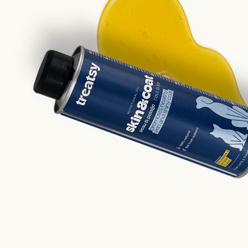 Blaue Dose mit schwarzem Deckel. Aufschrift: Treatsy, Skin & Coat. Gelbes Öl daneben.
