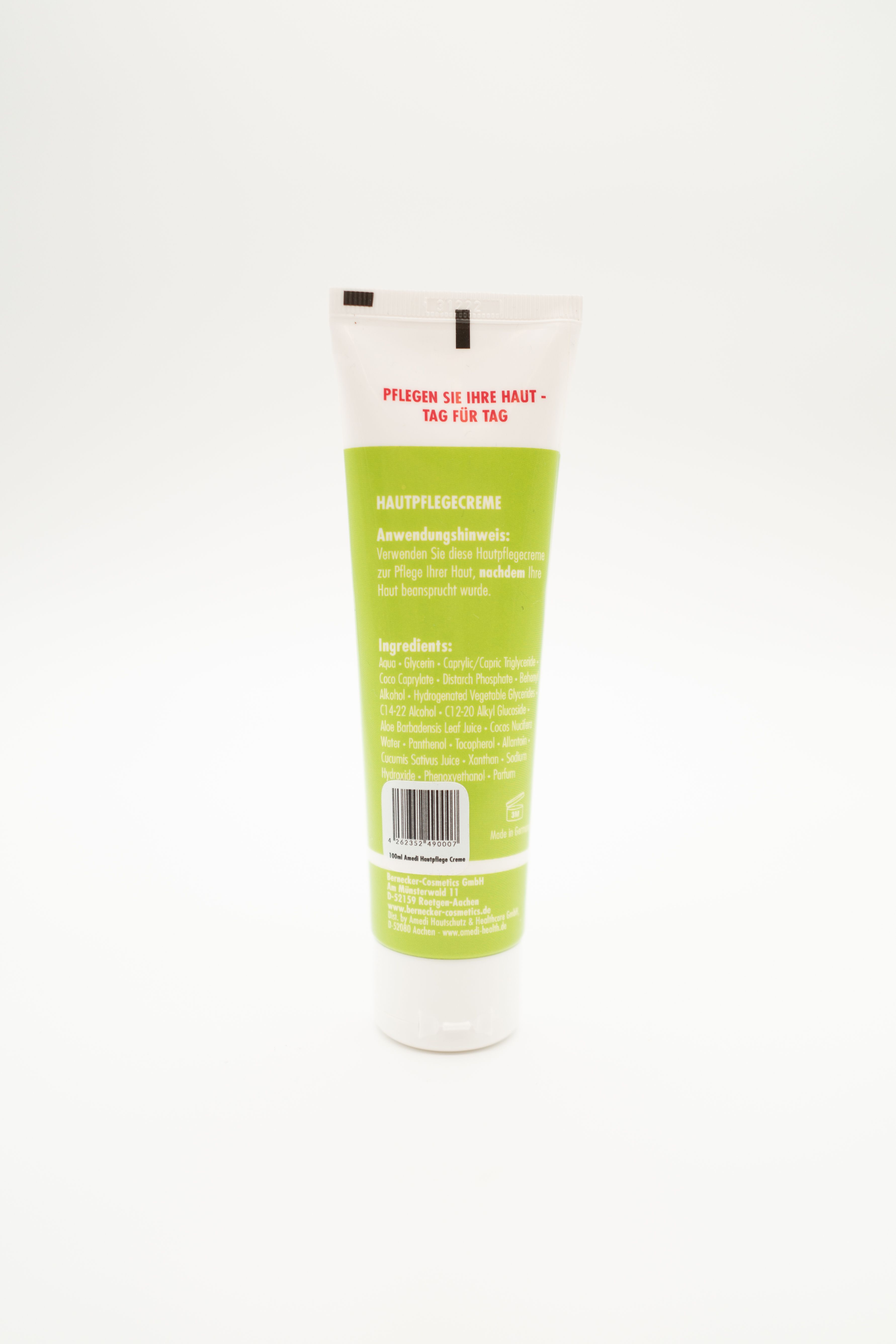 Rückseite einer grünen Tube mit weißem Deckel. Aufschrift: Hautpflegecreme. Text in Deutsch. Zutatenliste und Barcode.
