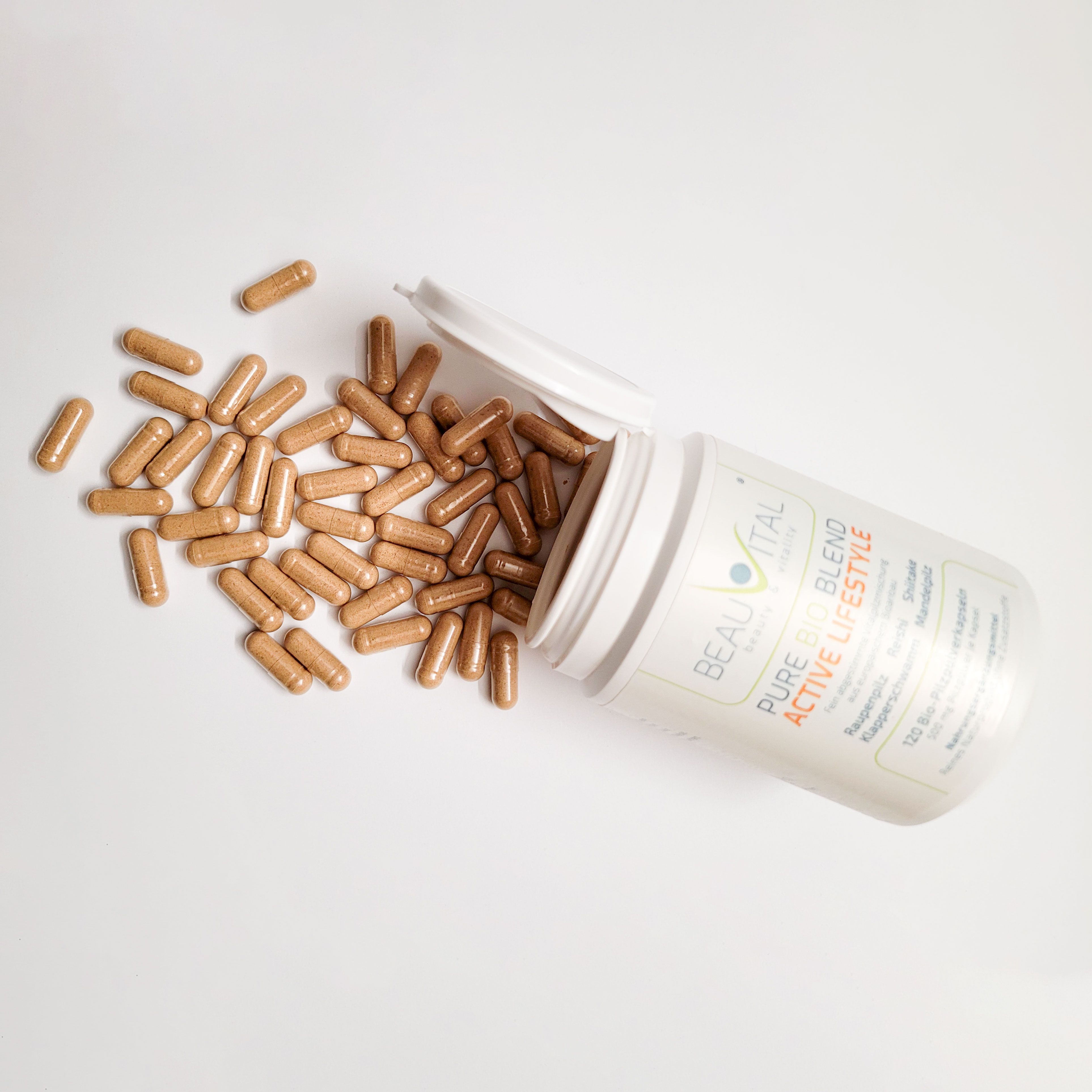 BEAUVITAL Active Lifestyle Kapseln, einige aus der Dose gestreut, mit EU Bio-Siegel.