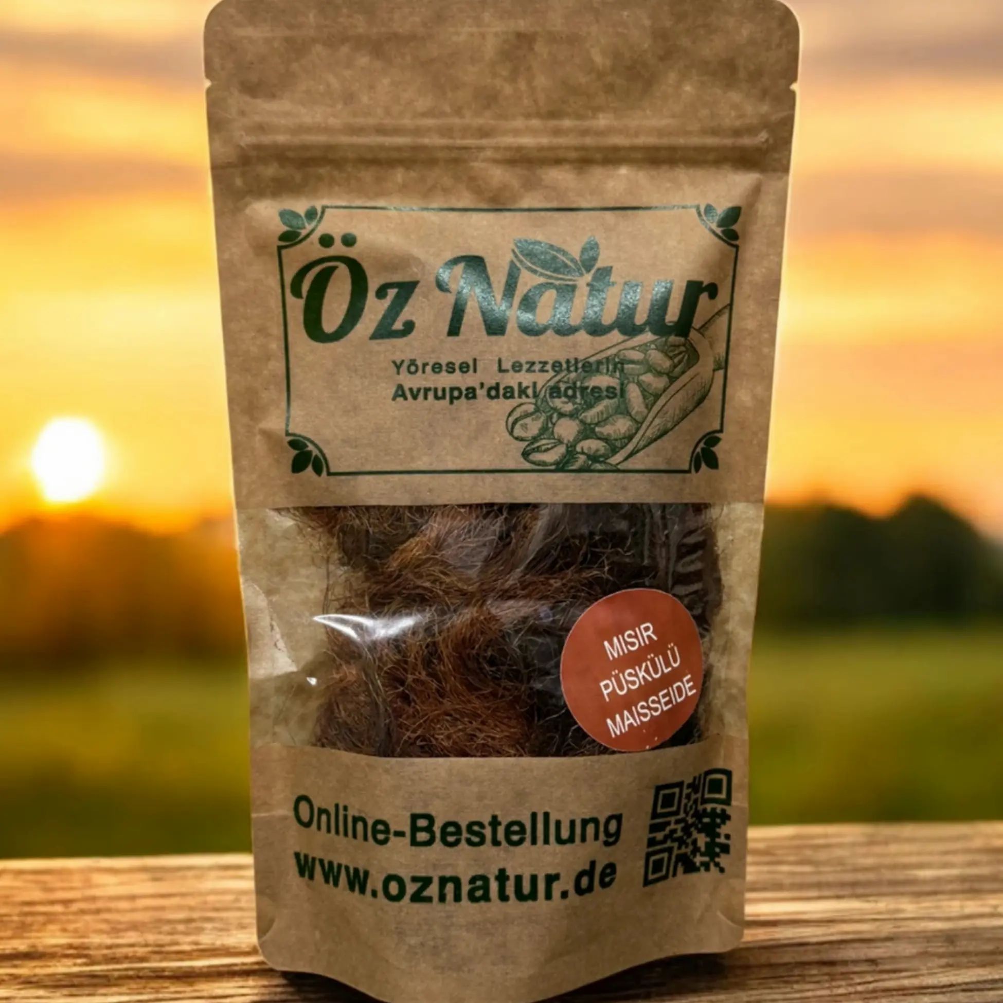 Beutel mit Maisseide. Sichtfenster zeigt Inhalt. Aufschrift: Öz Natur, Misir Püskülü Maisseide, Online-Bestellung www.oznatur.de. Hintergrund: Sonnenuntergang.