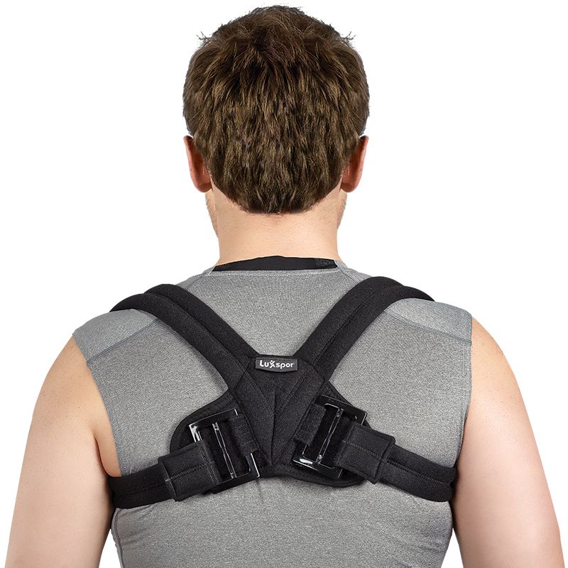 Schulterbandage, schwarz, mit Klettverschlüssen und Polsterung. Auf dem Rücken einer Person getragen.
