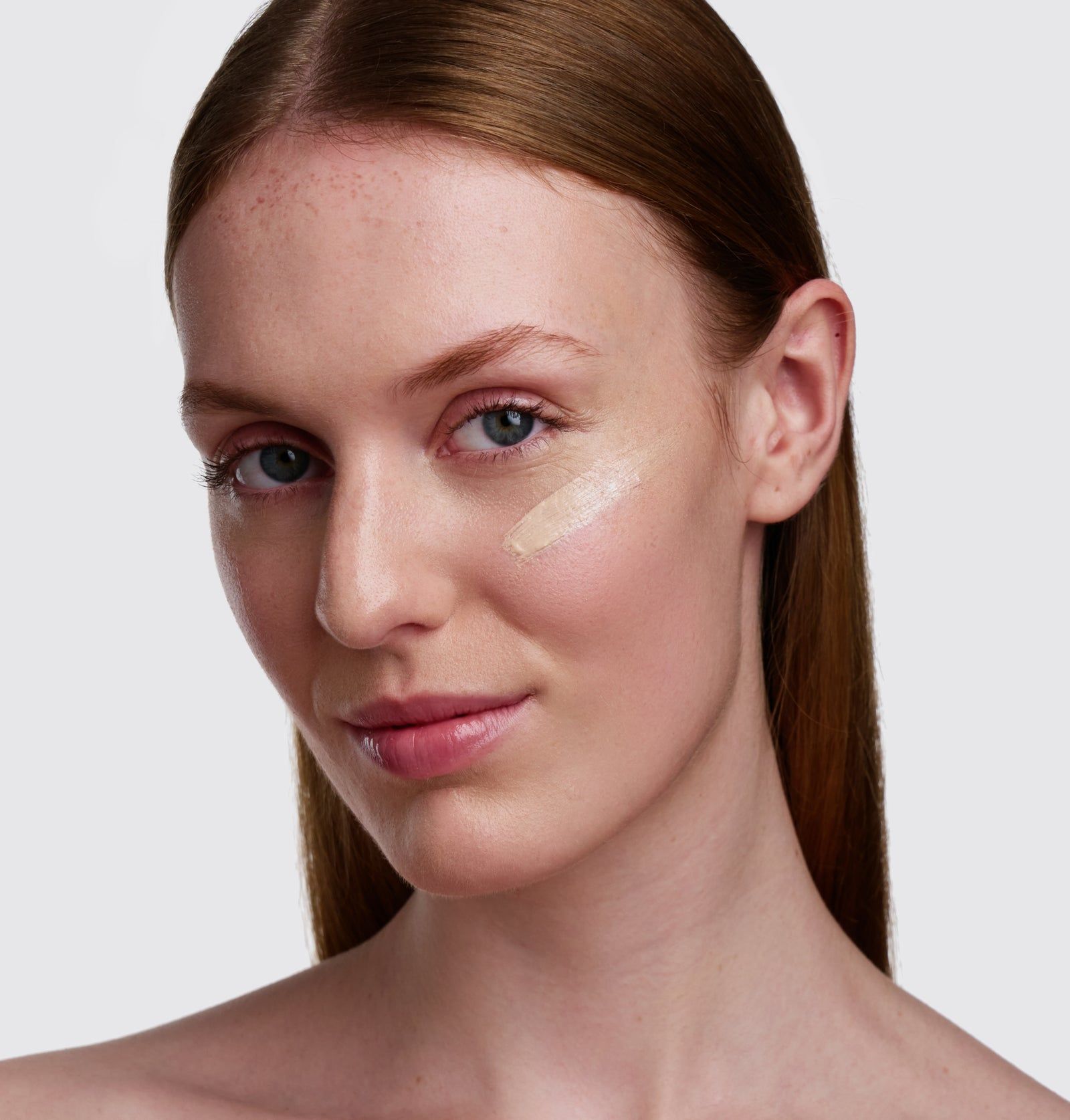 Gesicht einer Frau mit aufgetragener BB Primer. Auf der Haut ist der Primer sichtbar. Helle Haut, braune Haare.