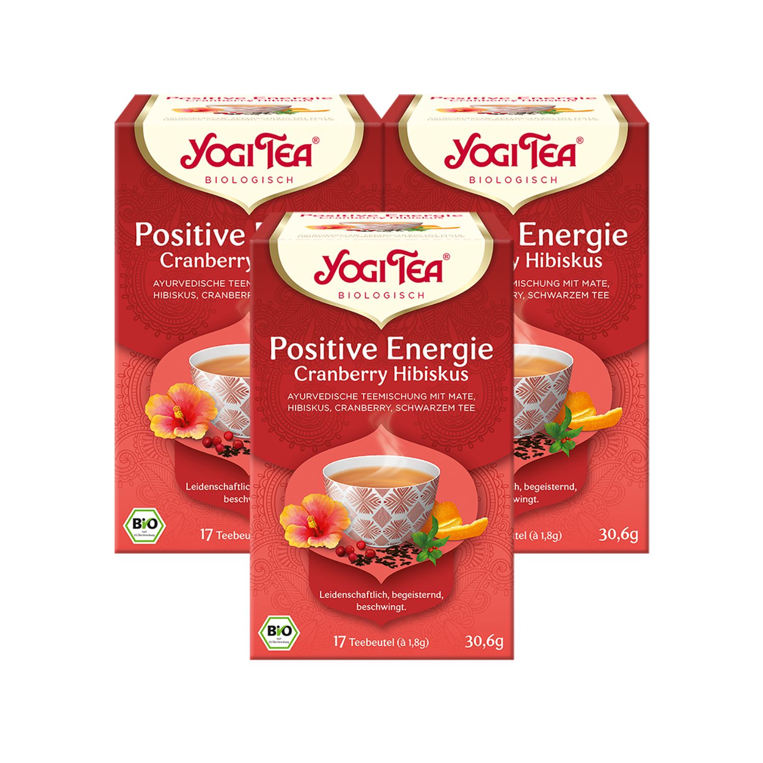 Drei Packungen Yogi Tea Positive Energie Bio Schwarztee. Rote Verpackung mit Logo, Produktname und Abbildung einer Tasse Tee.