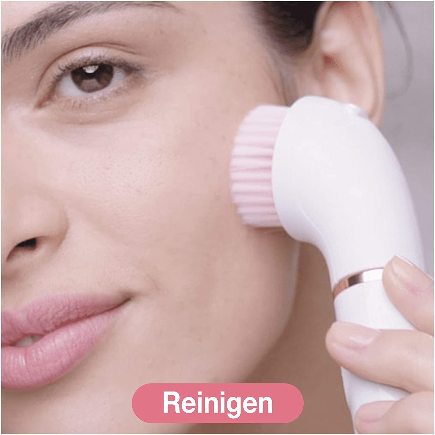 Nahaufnahme einer Frau, die eine Reinigungsbürste auf ihrem Gesicht verwendet. Text: Reinigen.