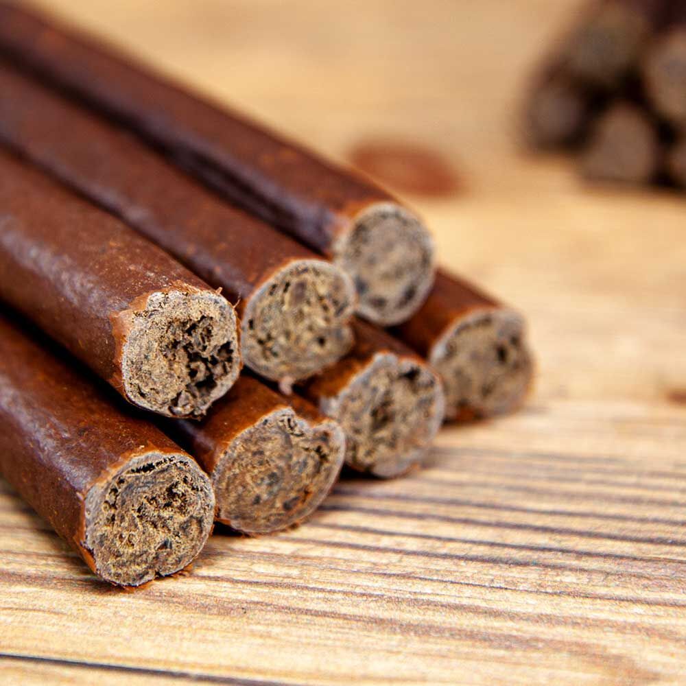 Nahaufnahme von Hundezigarren. Die Zigarren sind braun und haben eine unregelmäßige Form. Die Enden sind offen und zeigen das Innere.