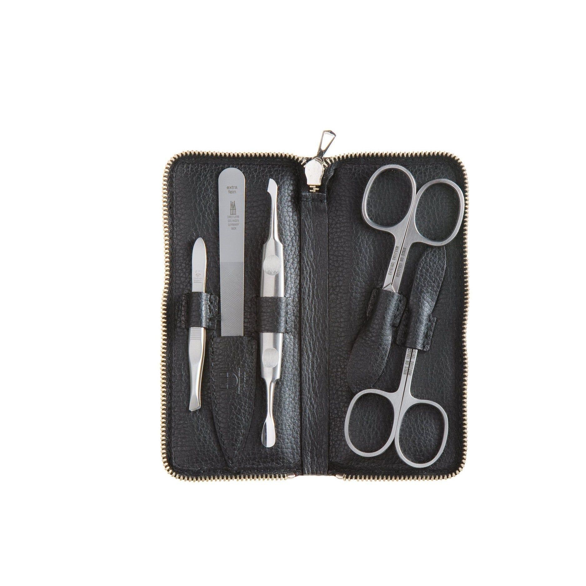 Schwarzes Etui mit Maniküre-Set. Enthält Nagelfeile, Pinzette, Nagelknipser und zwei Scheren. Reißverschluss.