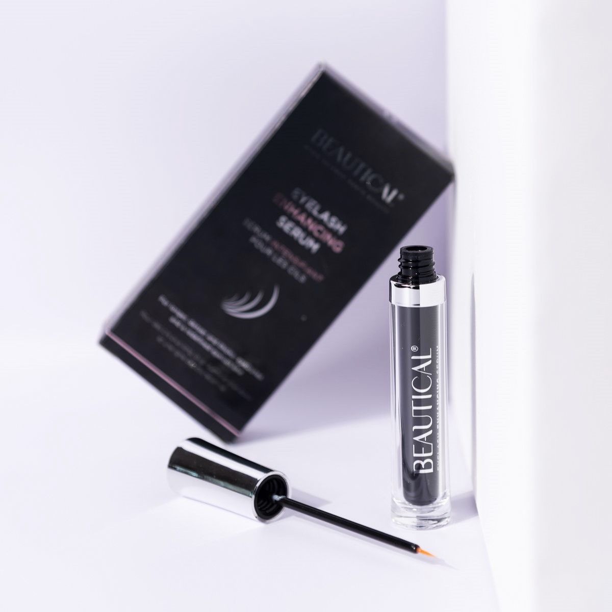 BEAUTICAL Wimpernserum. Produkt und Verpackung. Schwarze Schachtel und Flasche mit Applikator.