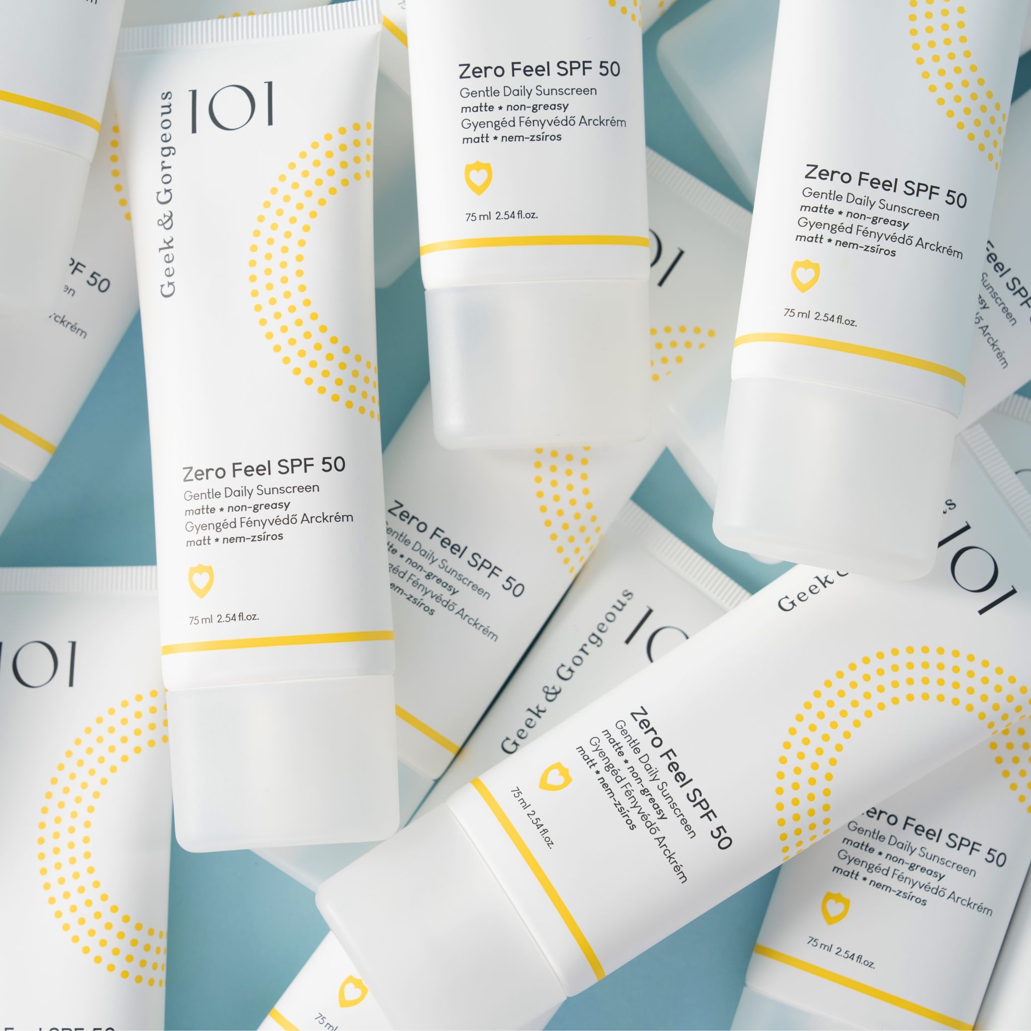 Mehrere Tuben "Zero Feel SPF 50" auf blauem Hintergrund. Marke: Geek & Gorgeous.