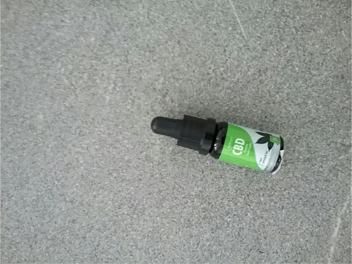 CBD-Öl 5% in einer kleinen Glasflasche mit Tropfer. Aufkleber mit Produktinformationen.