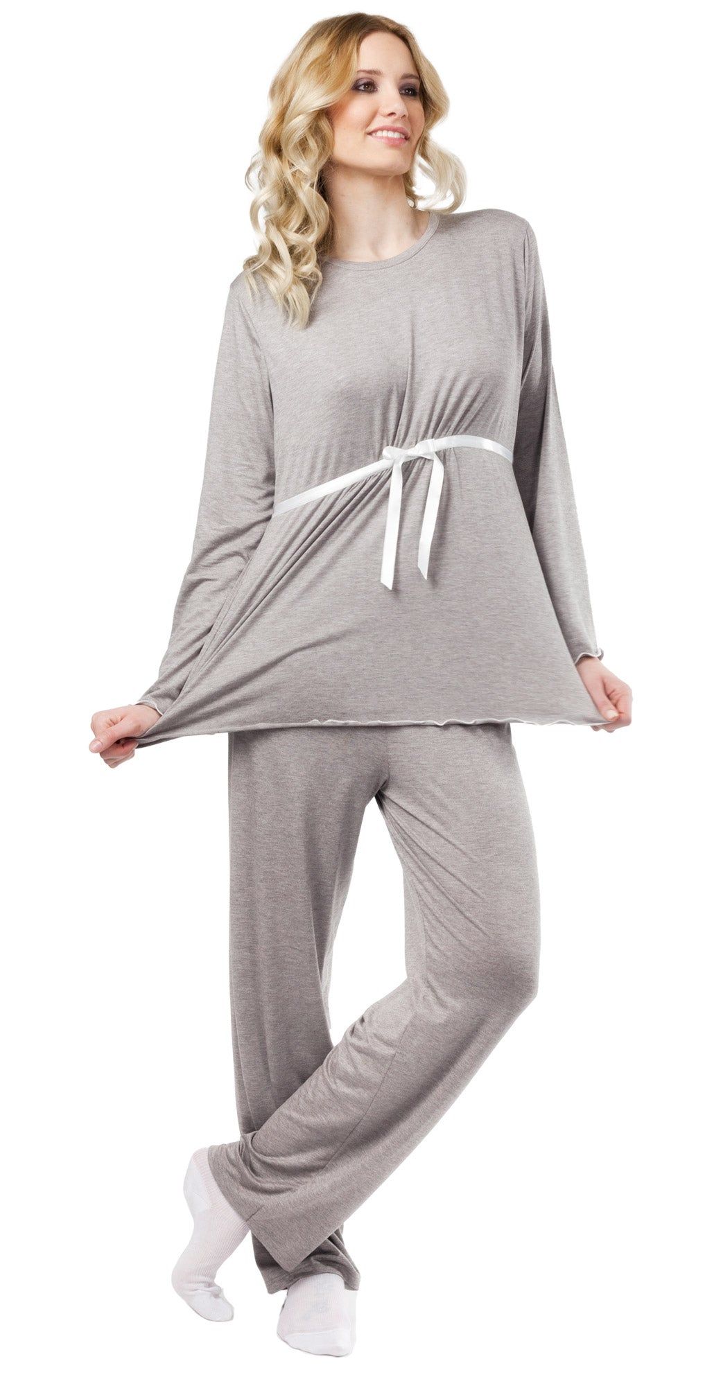 Grauer Schwangerschaftspyjama. Oberteil mit langen Ärmeln und weißem Bindeband. Hose mit geradem Bein. Frau trägt Pyjama.