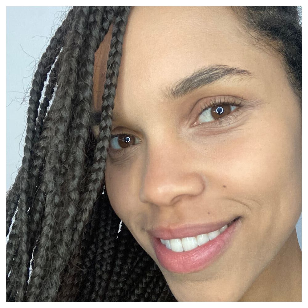 Nahaufnahme einer Frau mit Zöpfen. Hautton, Augenbrauen, Augen und Lippen sichtbar.