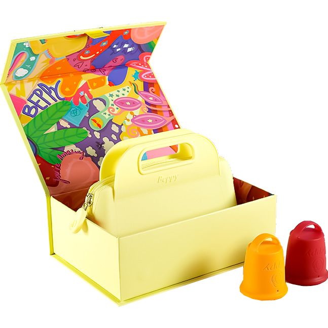 Gelbe Box mit Deckel, buntem Muster innen. Enthält eine gelbe Tasche mit Griff und zwei Beppy Cups. Ein Cup orange, einer rot.