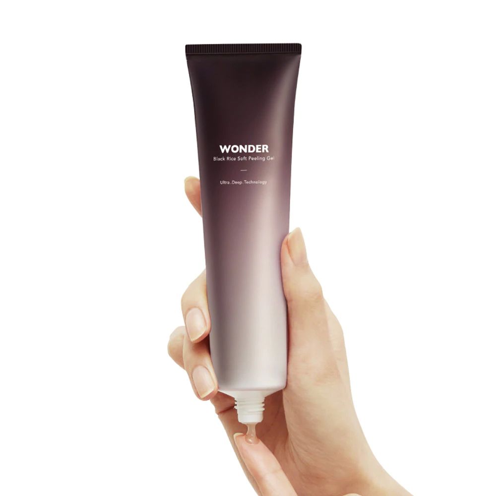 Hautpflegeprodukt in einer Tube. Farbverlauf von Dunkelbraun zu Weiß. Schriftzug 'WONDER'. Produkt wird von einer Hand gehalten.