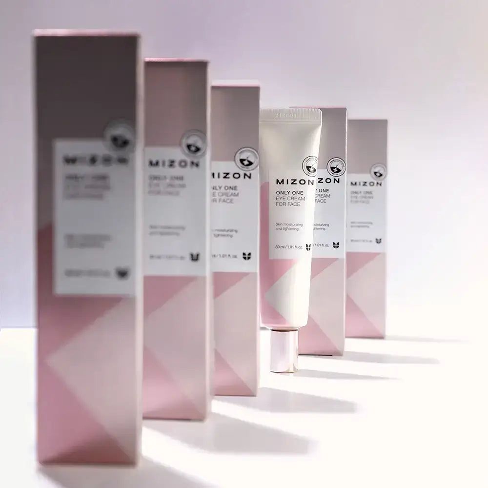Reihe von MIZON Augencreme-Verpackungen und einer Tube. Rosa und weiße Verpackung mit Produktnamen und Logo.