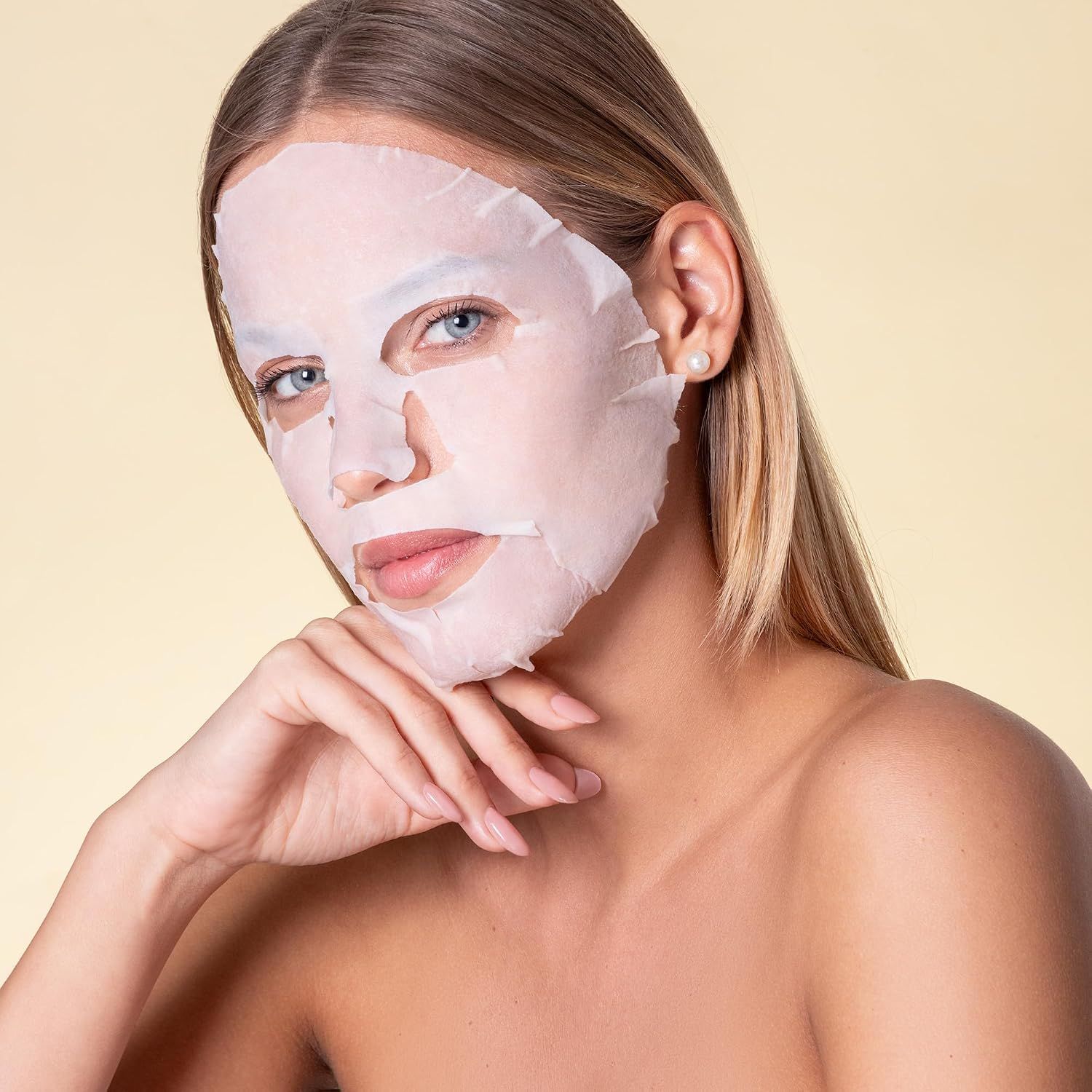 Frau mit einem Blattmasken-Tuch auf dem Gesicht.