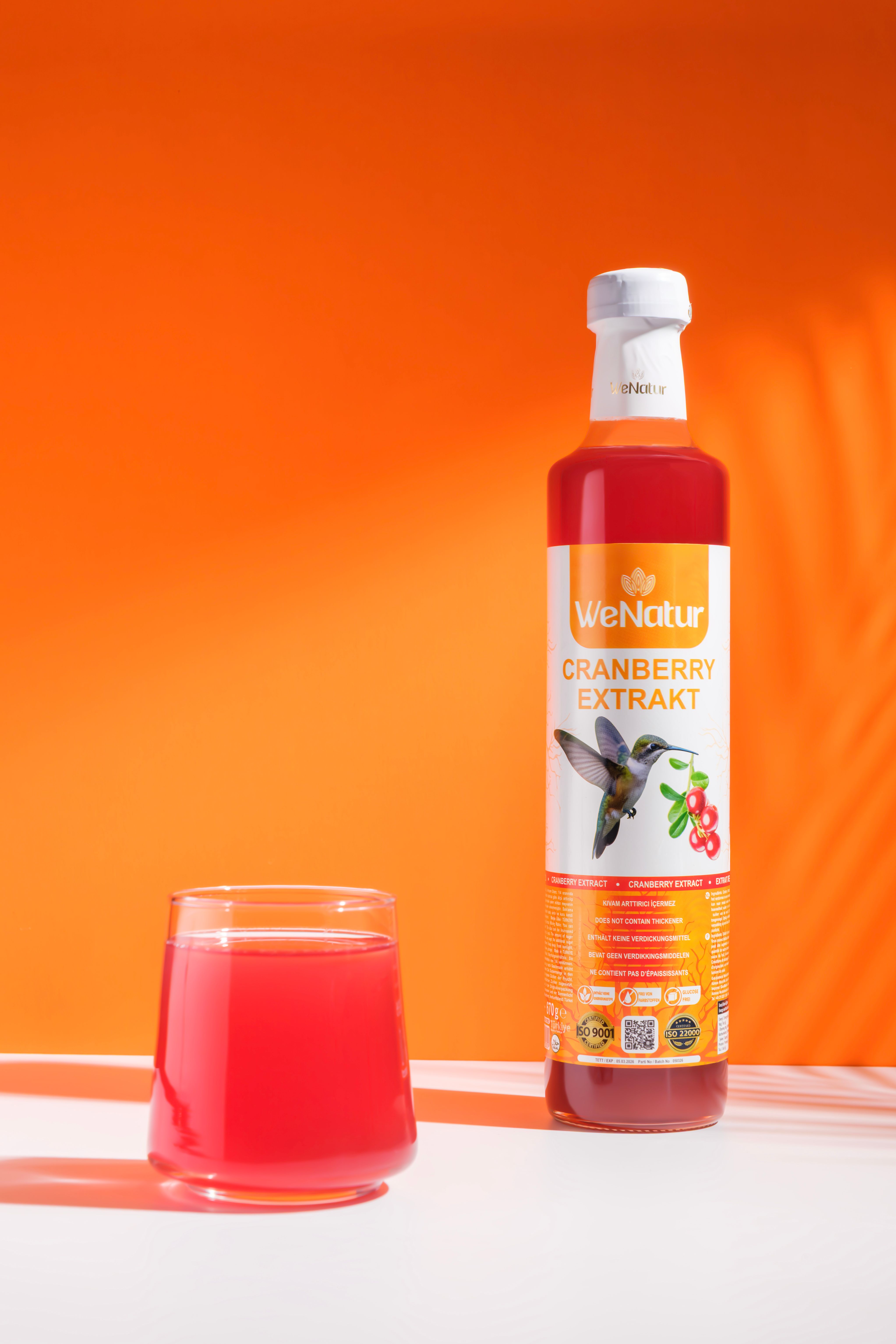 Flasche mit Cranberry-Extrakt und Glas mit Getränk.