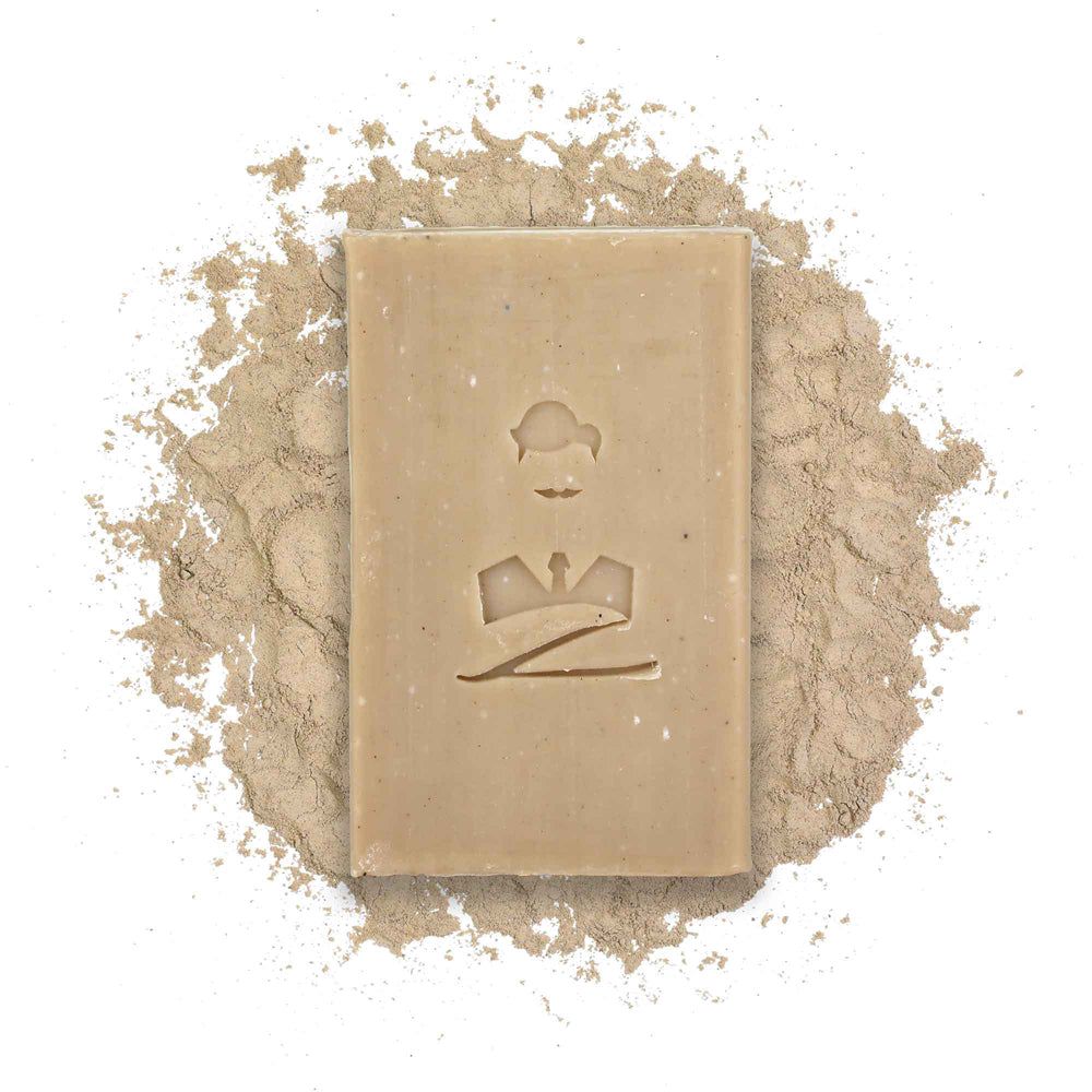 Rechteckige Seife auf braunem Pulver. Auf der Seife ist ein Mann abgebildet.