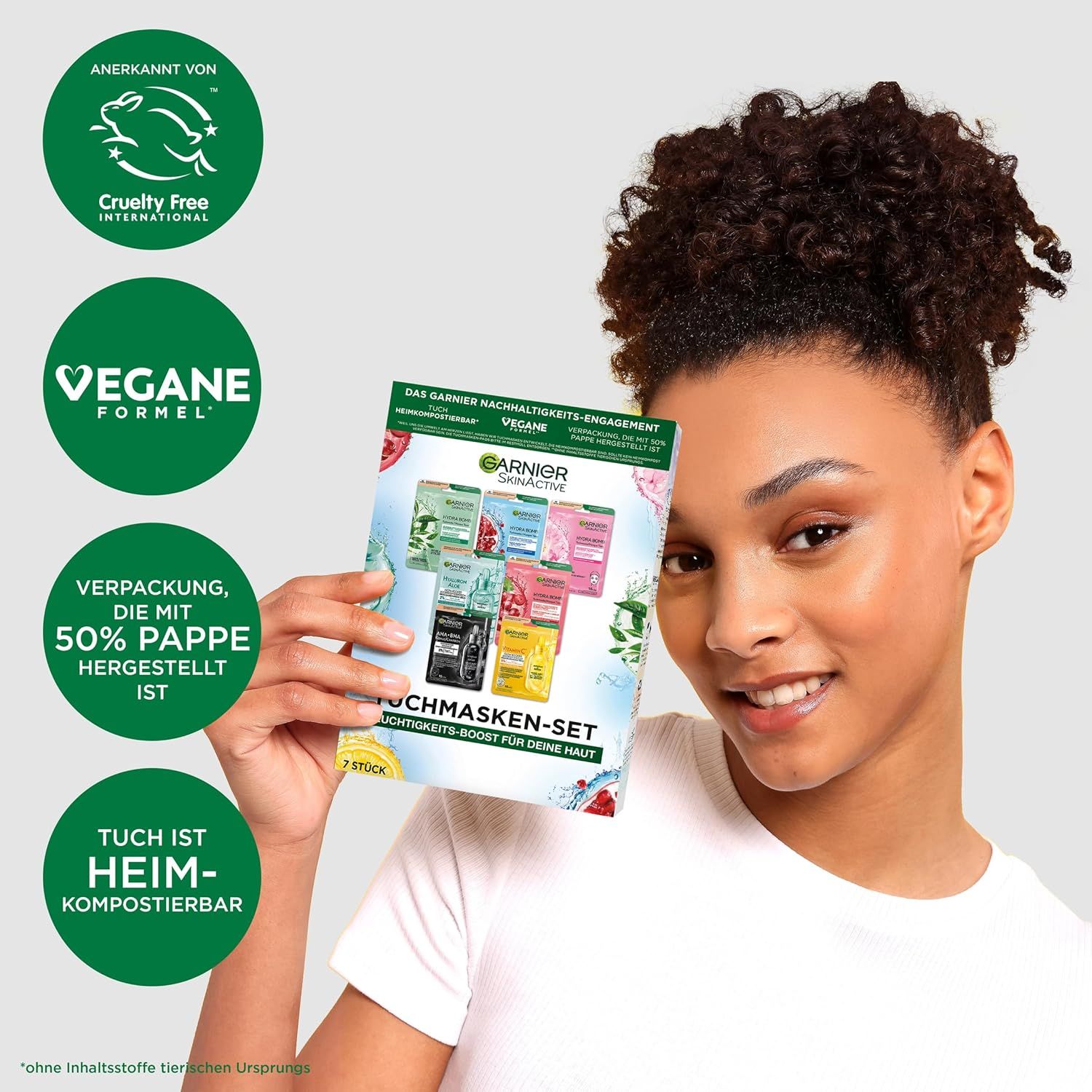 Frau hält Garnier Tuchmasken-Set. Aufdrucke: Garnier SkinActive, Tuchmasken-Set, Feuchtigkeits-Boost. Vegan, kompostierbar. Cruelty Free.