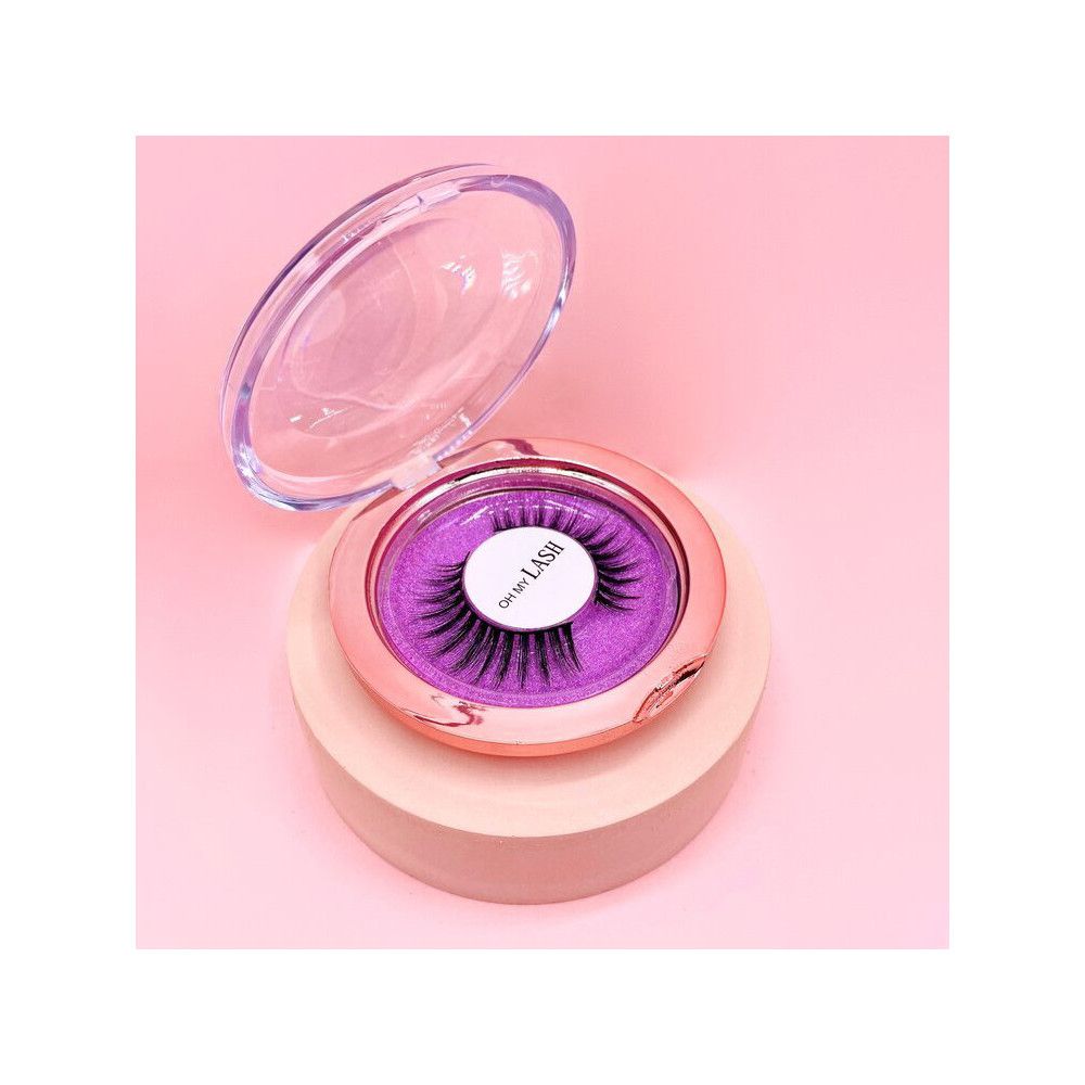 Falsche Wimpern in runder, offener Verpackung. Rosa-goldfarbener Behälter, durchsichtiger Deckel. Aufschrift "OH MY LASH".