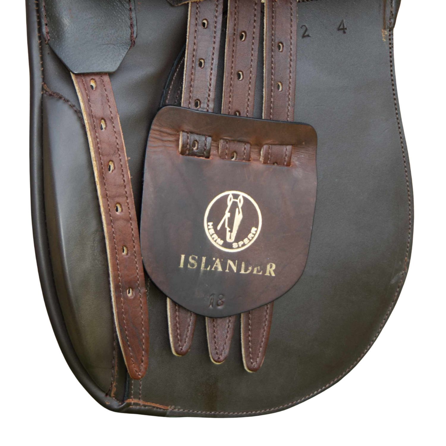 Nahaufnahme des Sattels mit Logo und Schriftzug ISLANDER. Braune Lederriemen und Halterung.