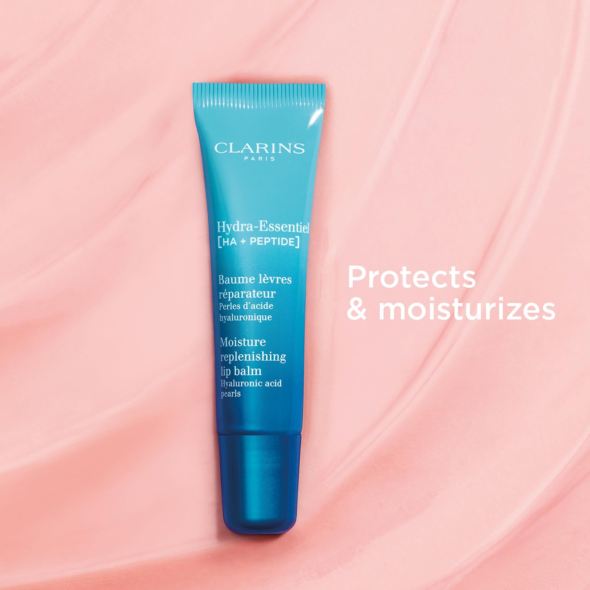 Clarins Hydra-Essentiel Lippenbalsam-Tube auf rosa Hintergrund. Text: Protects & moisturizes.