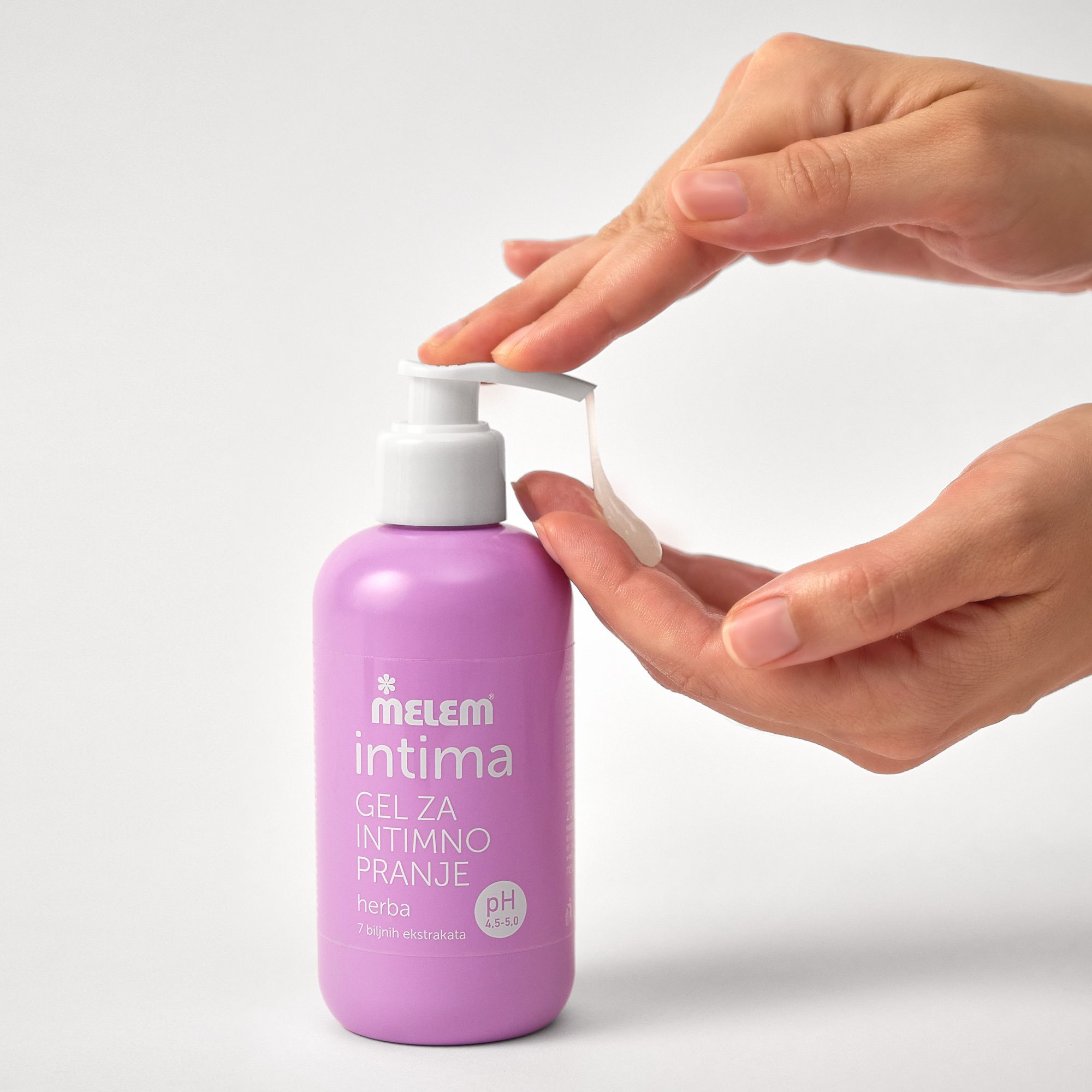Flasche Intim-Gel, lila, mit Pumpe. Hände drücken Gel aus. Aufschrift: Melem intima, Gel za intimno pranje, herba, pH 4.5-5.0.
