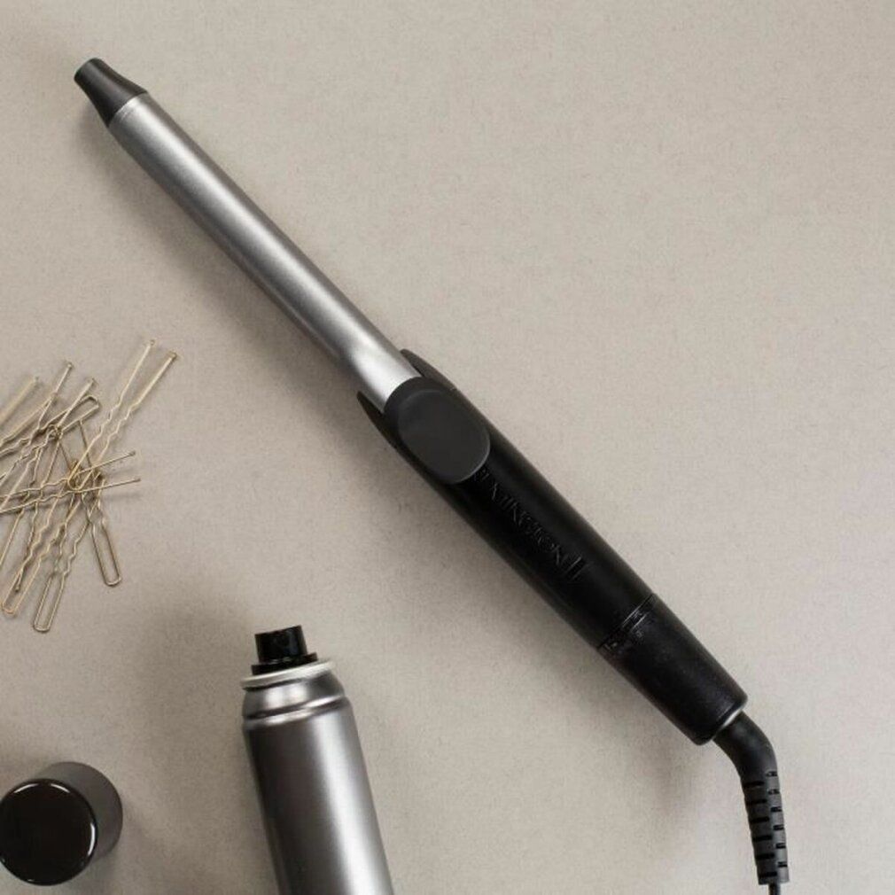 Lockenstab, silberfarben und schwarz. Neben Haarnadeln und Haarspray.