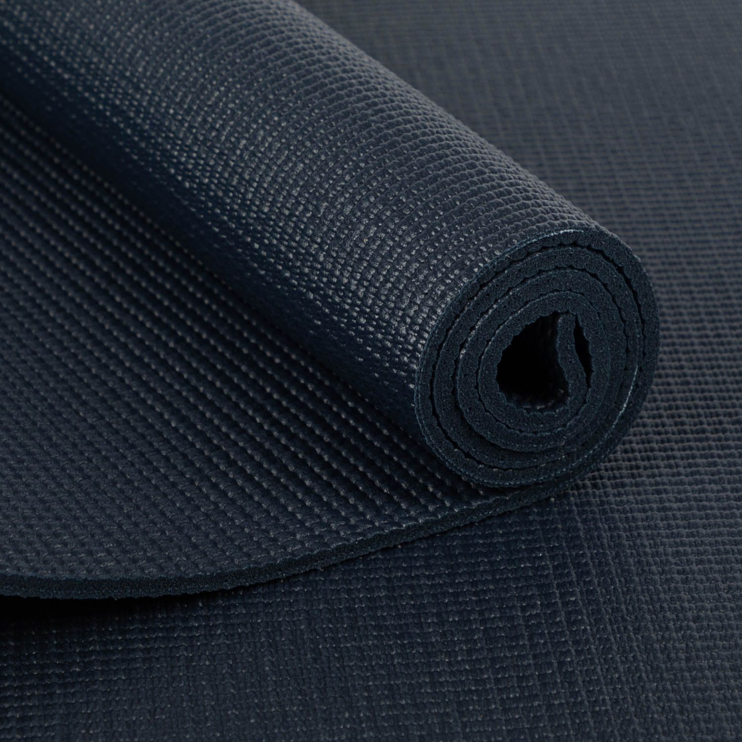 Nahaufnahme einer gerollten Yogamatte in Dunkelblau. Die Oberfläche ist strukturiert.