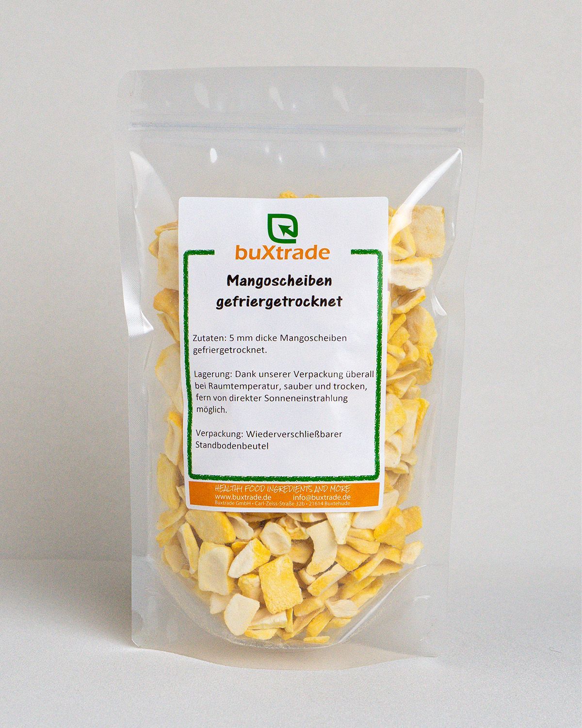 Transparente Verpackung mit gefriergetrockneten Mangoscheiben. Aufkleber mit Produktinformationen. Marke: buXtrade.