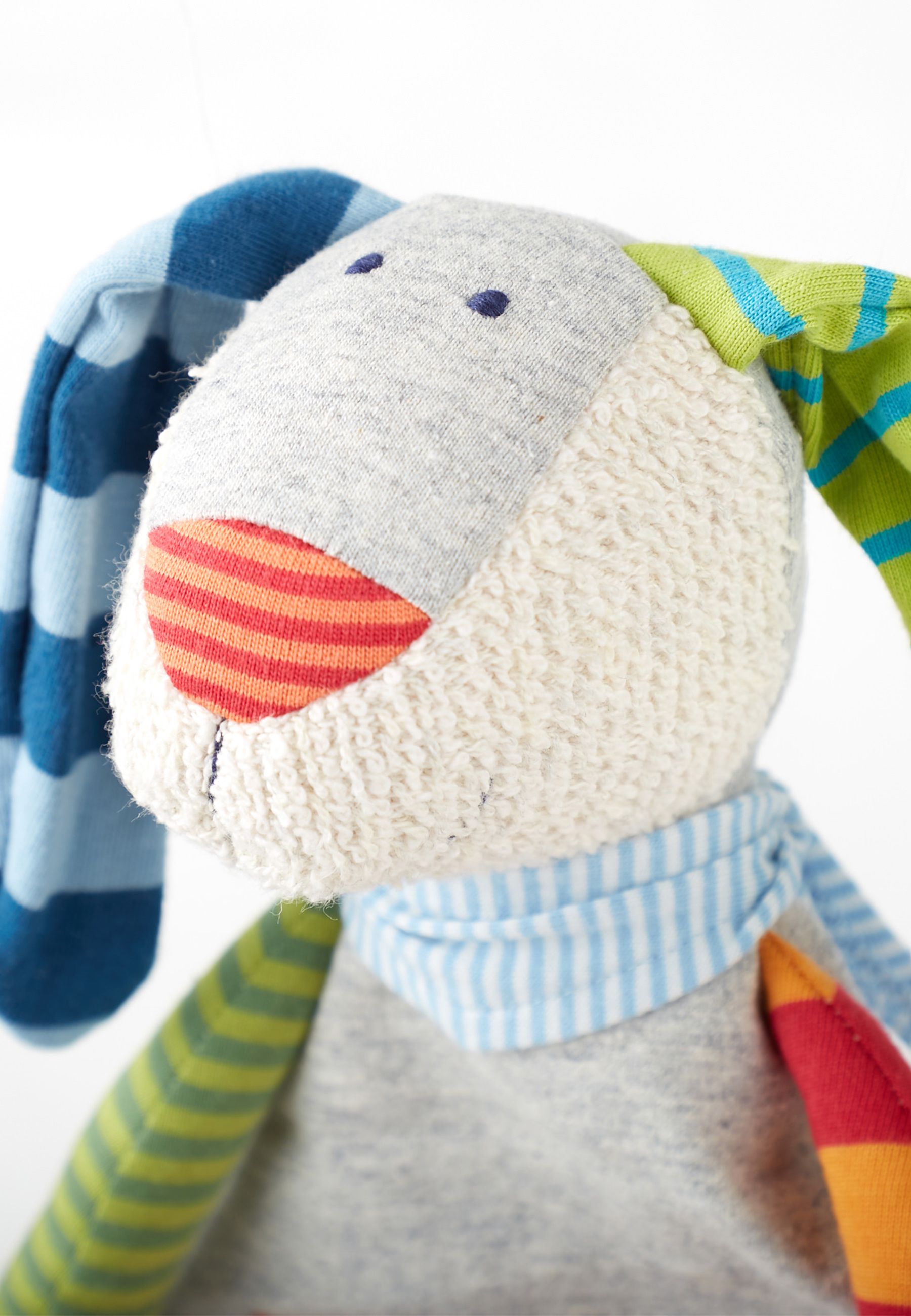 Nahaufnahme des SIGIKID Schnuffeltuchs. Hasenkopf mit gestreiften Ohren, roter Nase und blauem Halstuch.