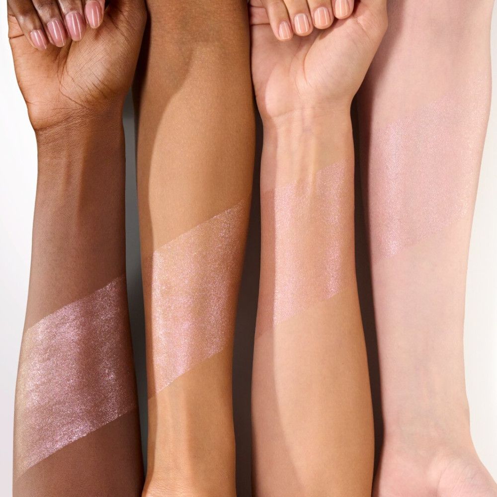 Arme mit Highlighter-Swatches. Unterschiedliche Hauttöne. Der Highlighter ist rosa und schimmert.