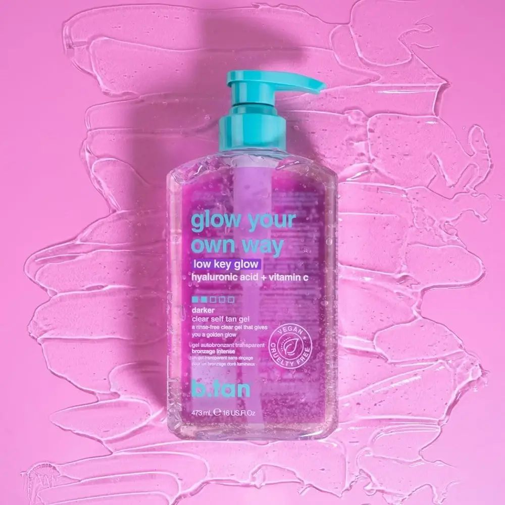 Transparente Flasche mit rosa Flüssigkeit und blauem Pumpkopf. Aufschrift: glow your own way low key glow. Vegan.