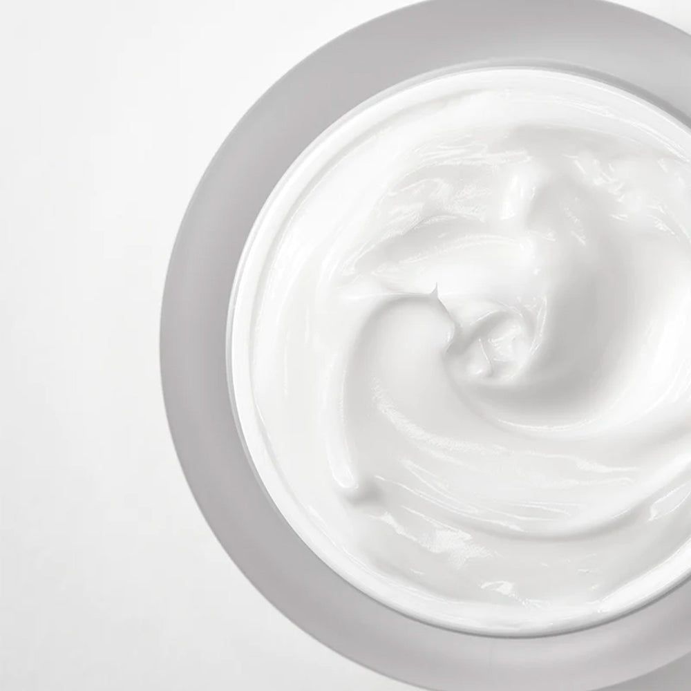 Draufsicht auf Creme in einem Tiegel. Weiße Creme, grauer Tiegel.