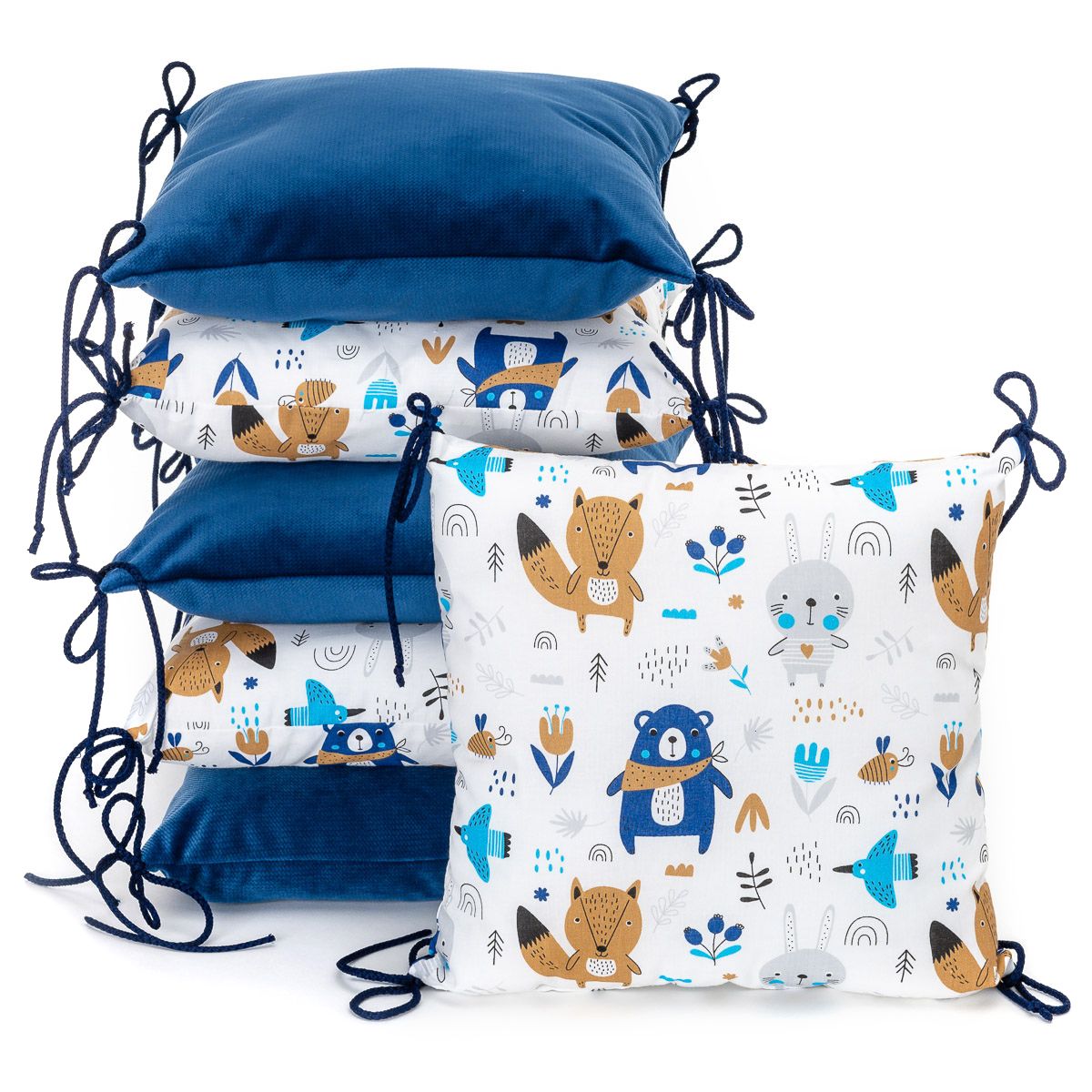 Sechs quadratische Kissen, abwechselnd blau und mit Tiermotiv, mit Bändern.