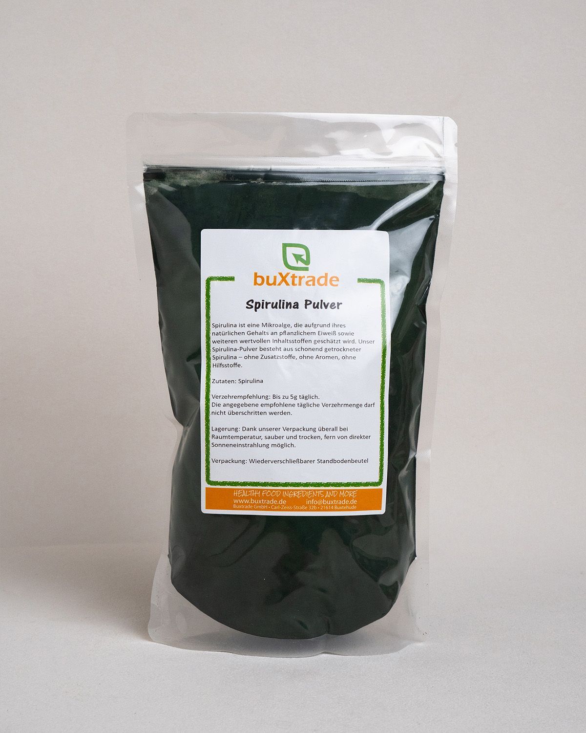Verpackung von buXtrade Spirulina-Pulver. Auf der Verpackung befindet sich ein Etikett mit Produktinformationen.