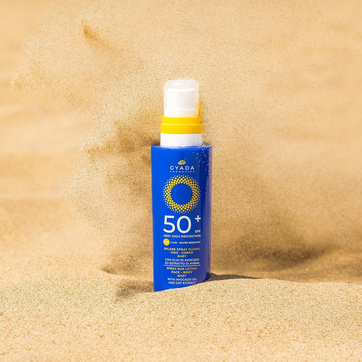 Blaue Flasche mit Sonnenschutzmittel LSF 50+ im Sand.