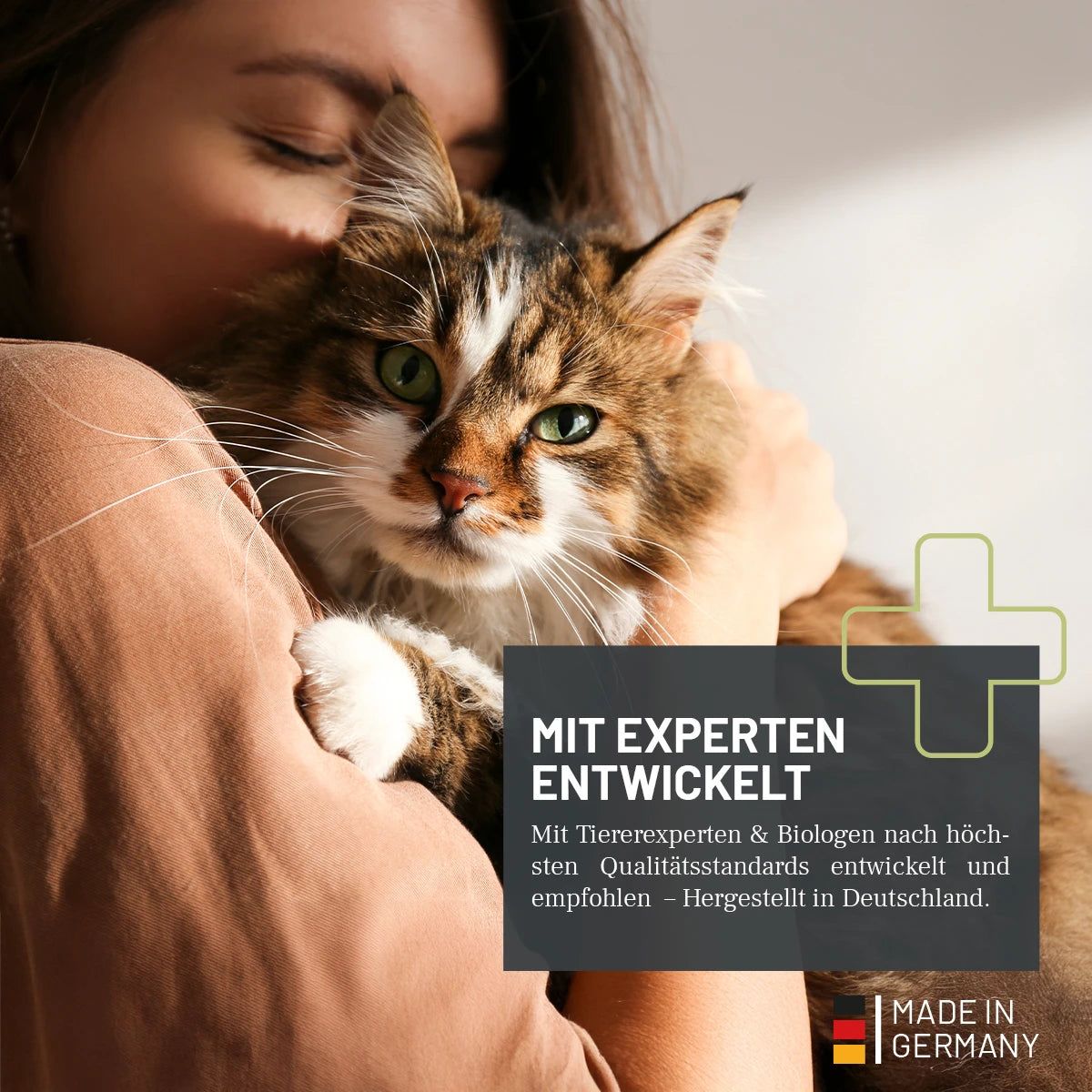 Frau umarmt Katze. Text: Mit Experten entwickelt. Hergestellt in Deutschland. Grünes Kreuz.