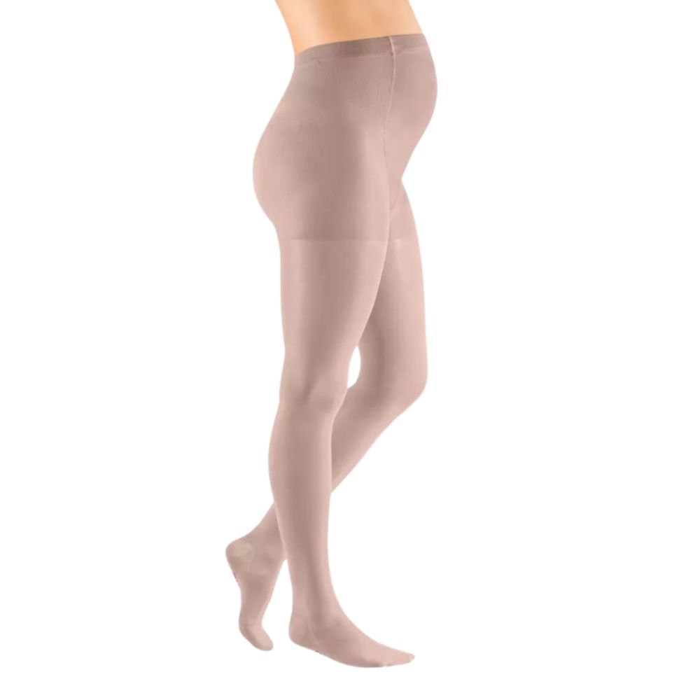 Hautfarbene Kompressions-Umstandshose. Seitliche Ansicht einer schwangeren Frau, die Strumpfhose trägt.