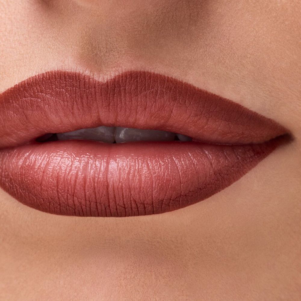 Nahaufnahme von Lippen, umrandet mit Lippenkonturenstift. Braun. Die Lippen sind geschminkt.