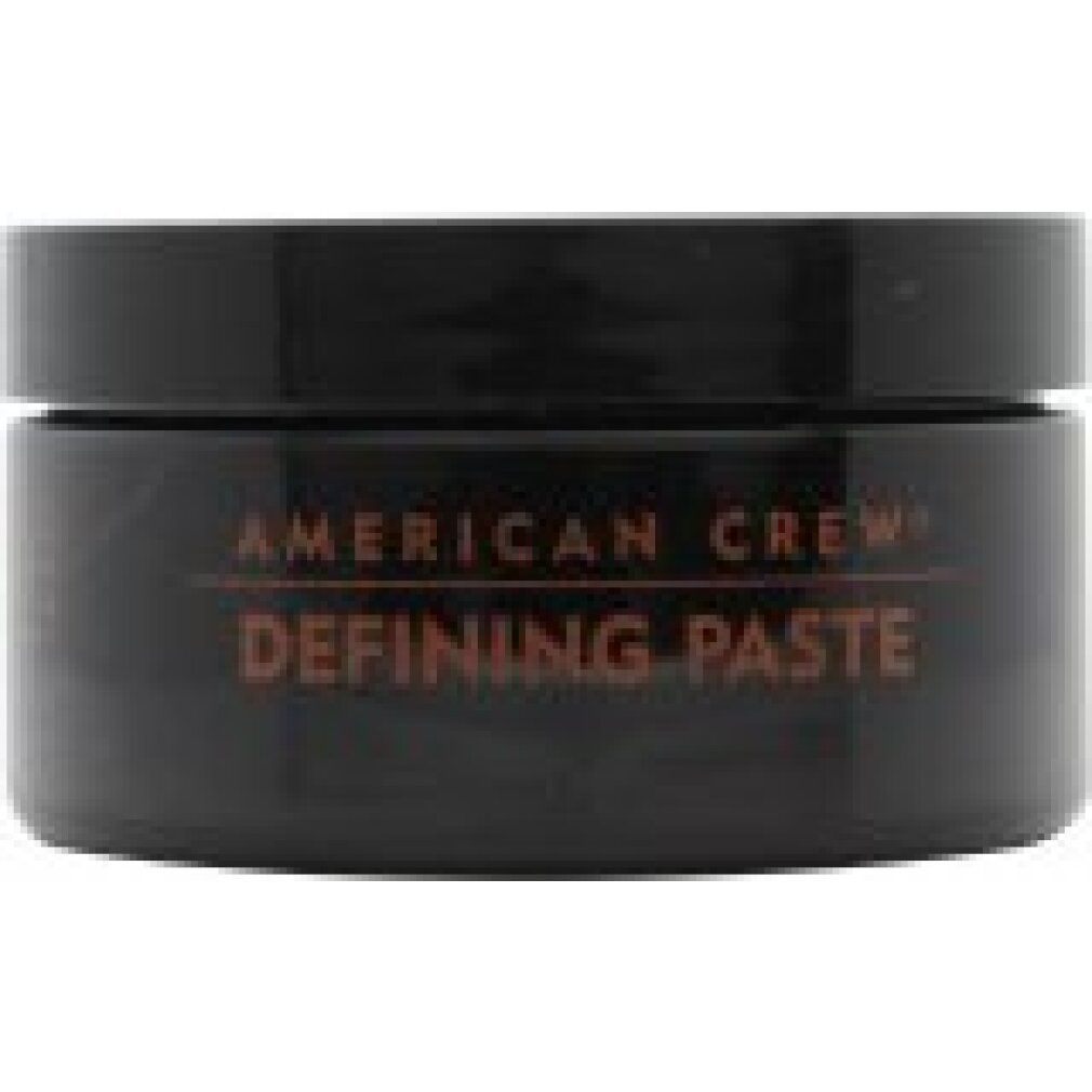 Runde, schwarze Dose mit rotem Deckel. Text: "American Crew Defining Paste".