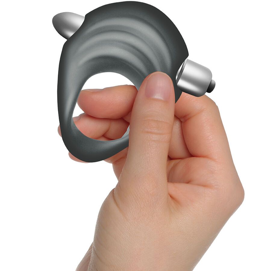 Grauer Penisring, gehalten von einer Hand. Ringförmig mit zwei silberfarbenen Elementen. Gefertigt aus flexiblem Material.