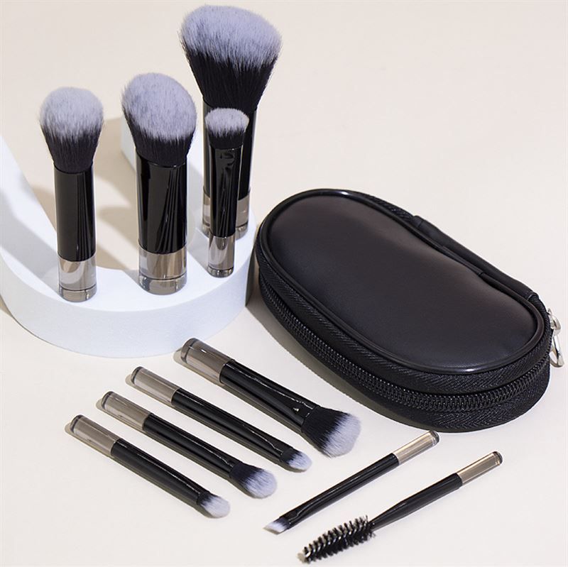 Schwarzes Etui mit Reißverschluss und Make-up-Pinsel-Set. Pinsel mit schwarzen Griffen und silbernen Enden.